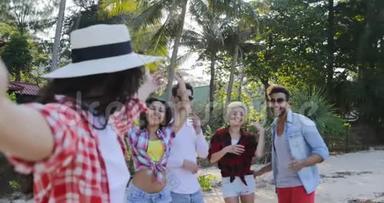 女孩欢迎<strong>人们</strong>团体在手机智能手机上<strong>自拍</strong>，在热带棕榈树上谈论快乐的男人和女人